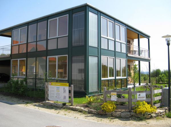 Würfelförmiges, fensterreiches Passivhaus mit Garten und Balkonen