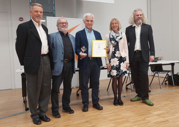 Gruppenbild bei der Preisverleihung: MR DI Michael Paula hält Urkunde und Trophäe in den Händen.