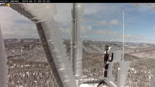 Webcam-Aufnahme von Aufbauten auf dem Maschinenhaus einer Windkraftanlage mit erkennbarer Vereisung, die von Struktur und Konsistenz direkt an den Aufbauten Klareis entspricht und im weiteren Verlauf in harten Reif übergeht. Die Anlage steht an einem Teststandort Nergica Zentrums für angewandte Forschung im Osten Kandas. Die Webcam-Aufnahme ist Teil eines Datensatzes in der "Task 54 Icing Event Database".